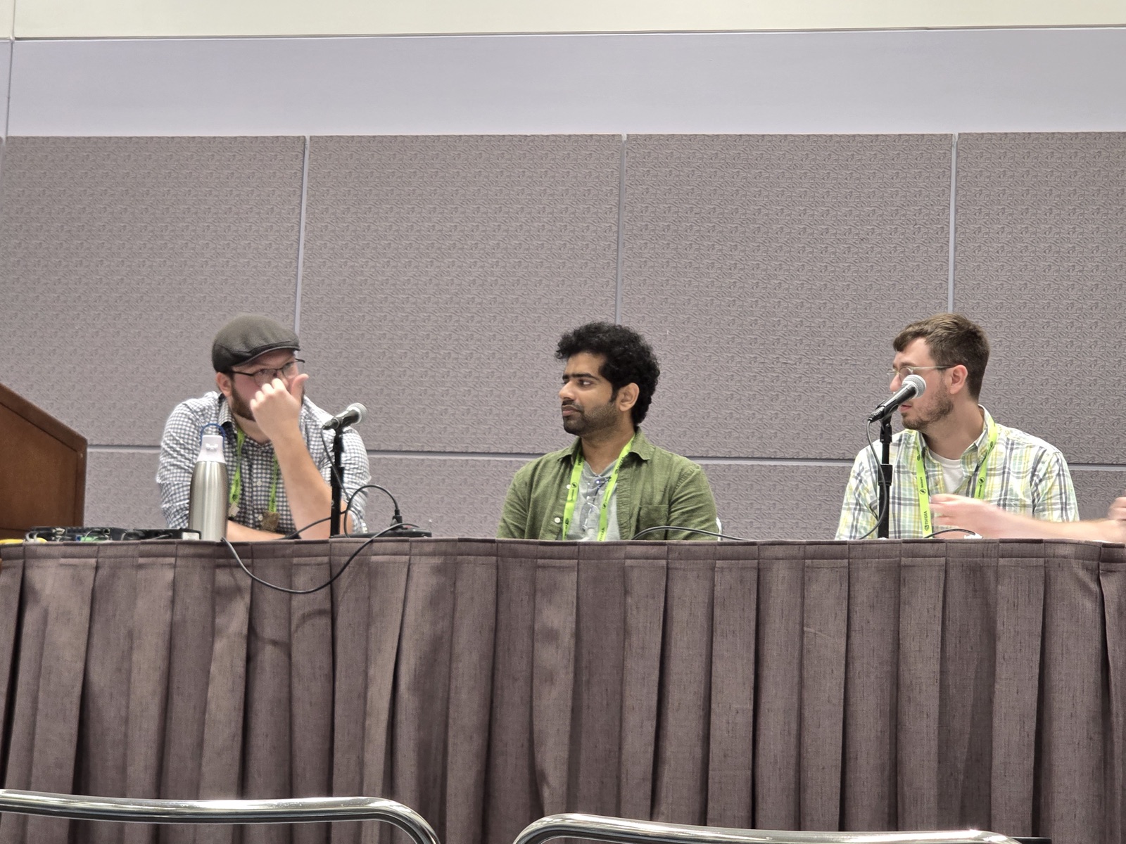 Three panelists seated at a table with microphones during the PRICE Workshop panel discussion